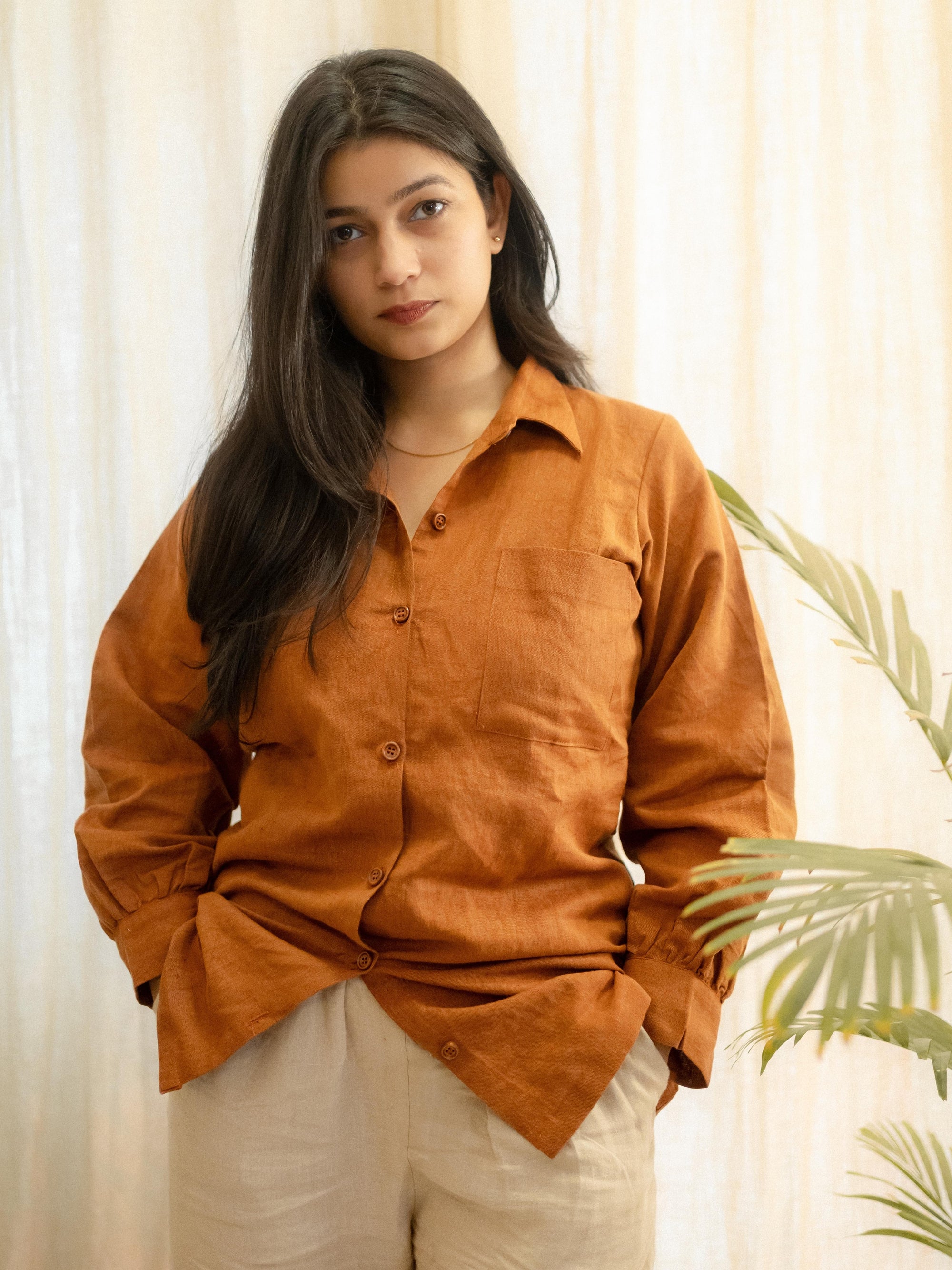 Woman wearing a brown shirt with a neutral background